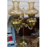 A twin-branch brass oil lamp with lustre shades, height 70cm overall