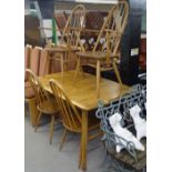 An Ercol oak extending dining table, on splayed leg base, together with a set of 4 Ercol stick-