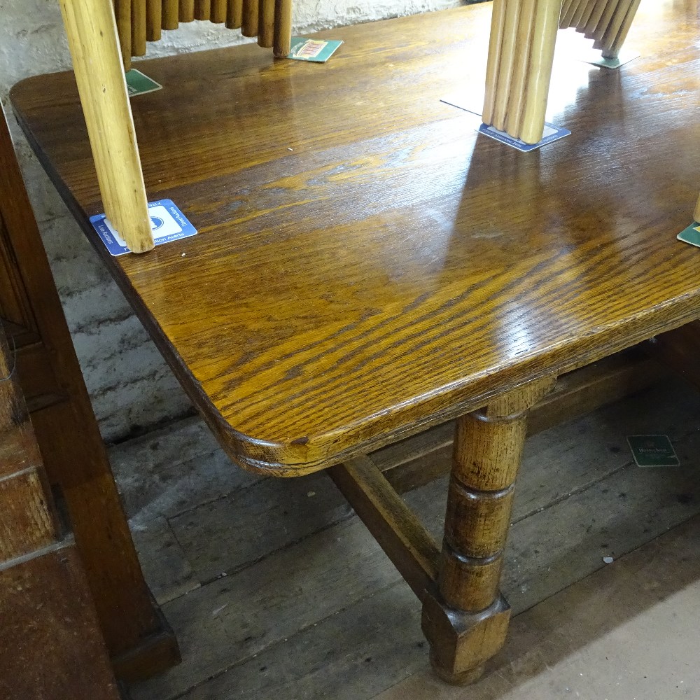 A large oak refectory dining table, on turned legs and H-shaped stretcher, L305cm, D89cm, H77cm