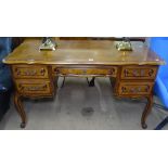 A Continental walnut knee-hole writing desk, with 5 short fitted drawers, raised on cabriole legs,