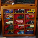2 glazed wall-mounted display cabinets, containing vans and locomotives