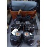 A leather-cased pair of Wray 11x60 coated binoculars, Pentax 8x40 binoculars, and Bresser 10x50
