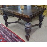 A large oak draw leaf dining table, raised on heavy carved acanthus leaf baluster legs, and shaped