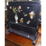 An Oriental black lacquered fire screen, having a hardstone and chinoiserie decorated panel,