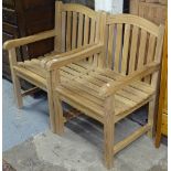 A pair of slatted teak garden armchairs