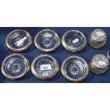 6 unmarked silver-mounted coasters, and a pair of embossed silver-topped dressing table bottles