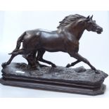 A patinated spelter galloping horse on naturalistic plinth, length 48cm overall