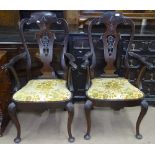A pair of Edwardian mahogany elbow chairs, with carved and pierced splat-backs, upholstered seats,
