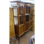 An Edwardian mahogany bow-front display cabinet, with lattice glazed doors above panelled cupboards,