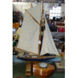 A Smiths clock mounted in a section of propeller, 27cm across, dominoes, and a model sailing boat on