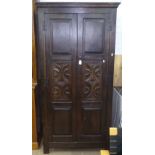 A 1920s joined oak hall cupboard, with 2 carved panelled doors, on stile legs, W92cm, H183cm