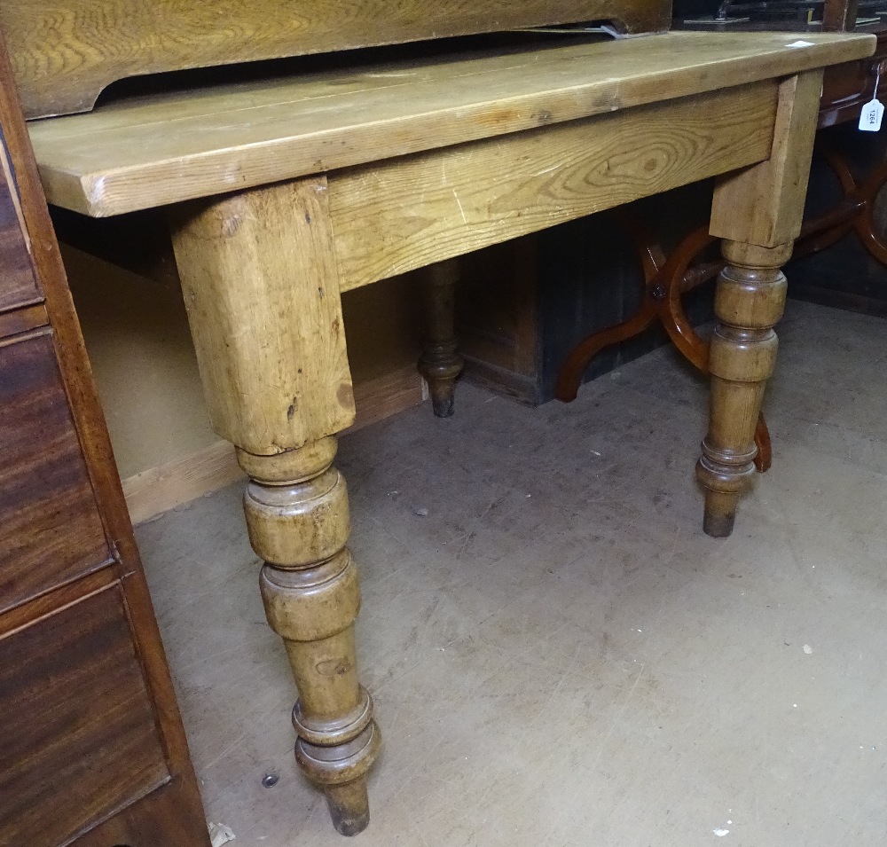 A Vintage pine plank-top kitchen table, with baluster legs