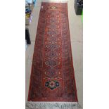 A red ground Shiraz machine made wool runner, 250cm x 67cm