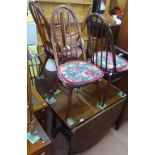 An oak oval drop leaf dining table, together with a set of 6 elm stick-back dining chairs