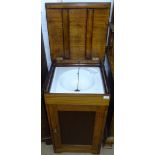 A 20th century mahogany washstand, the rising top revealing a fitted ceramic sink, with cupboard
