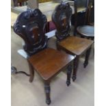 A pair of Victorian mahogany shield-back hall chairs, on turned legs