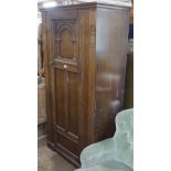 A 1920s carved and panelled oak hall cupboard, with single door, W92cm, H180cm