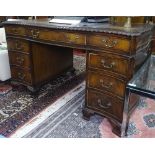 A serpentine-front mahogany twin-pedestal writing desk, with fitted drawers on bracket feet