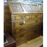 A Jaycee oak bureau, having a carved panelled fall-front with fitted interior, 2 short and 3 long