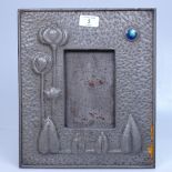 An Art Nouveau pewter strut photo frame, with stylised floral decoration and ceramic boss, height