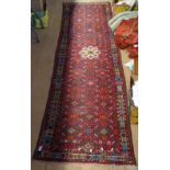 A red ground Turkish runner, with symmetrical pattern, L290cm x 80cm