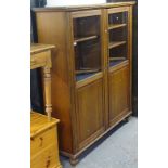 An Edwardian stained wood cabinet with 2 glazed panelled doors, on bun feet, W144cm, H167cm