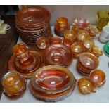 A large quantity of orange Carnival Glass dinner and teaware