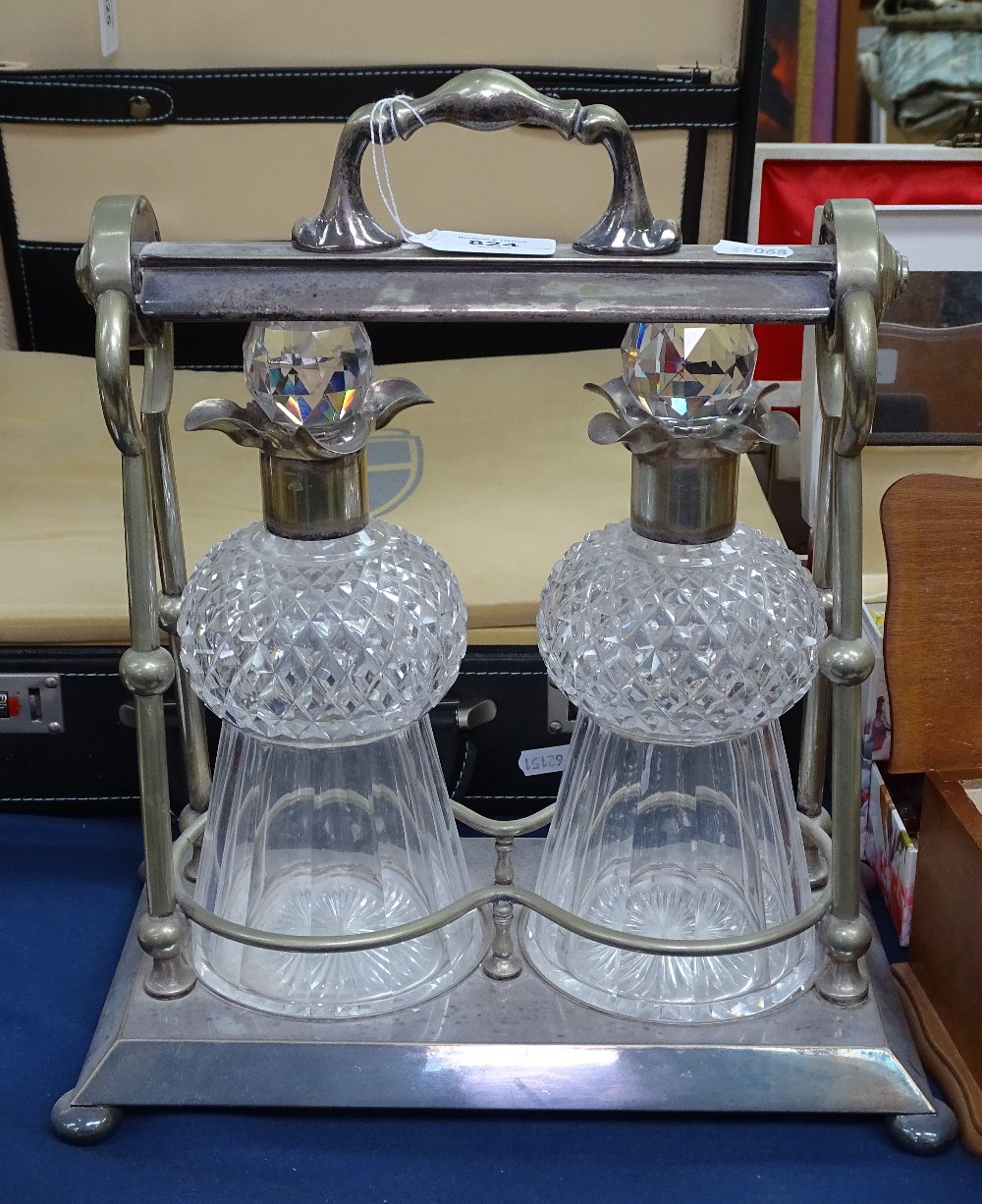 A silver plated tantalus, with 2 cut-glass decanters and stoppers, unsigned