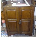 An Arts and Crafts oak cupboard, with spade cut out raised gallery, and maker's label for Lee