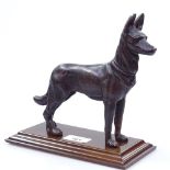 A bronze figure of a German Shepherd on a mahogany plinth, length 22cm overall