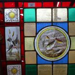 A Victorian brass and stained glass firescreen, with inset leadlight panels depicting birds and