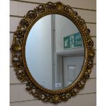 An oval wall mirror in Florentine style gilded frame, height 64cm