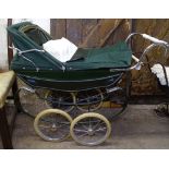 A coach built Silver Cross green pram and 2 dolls