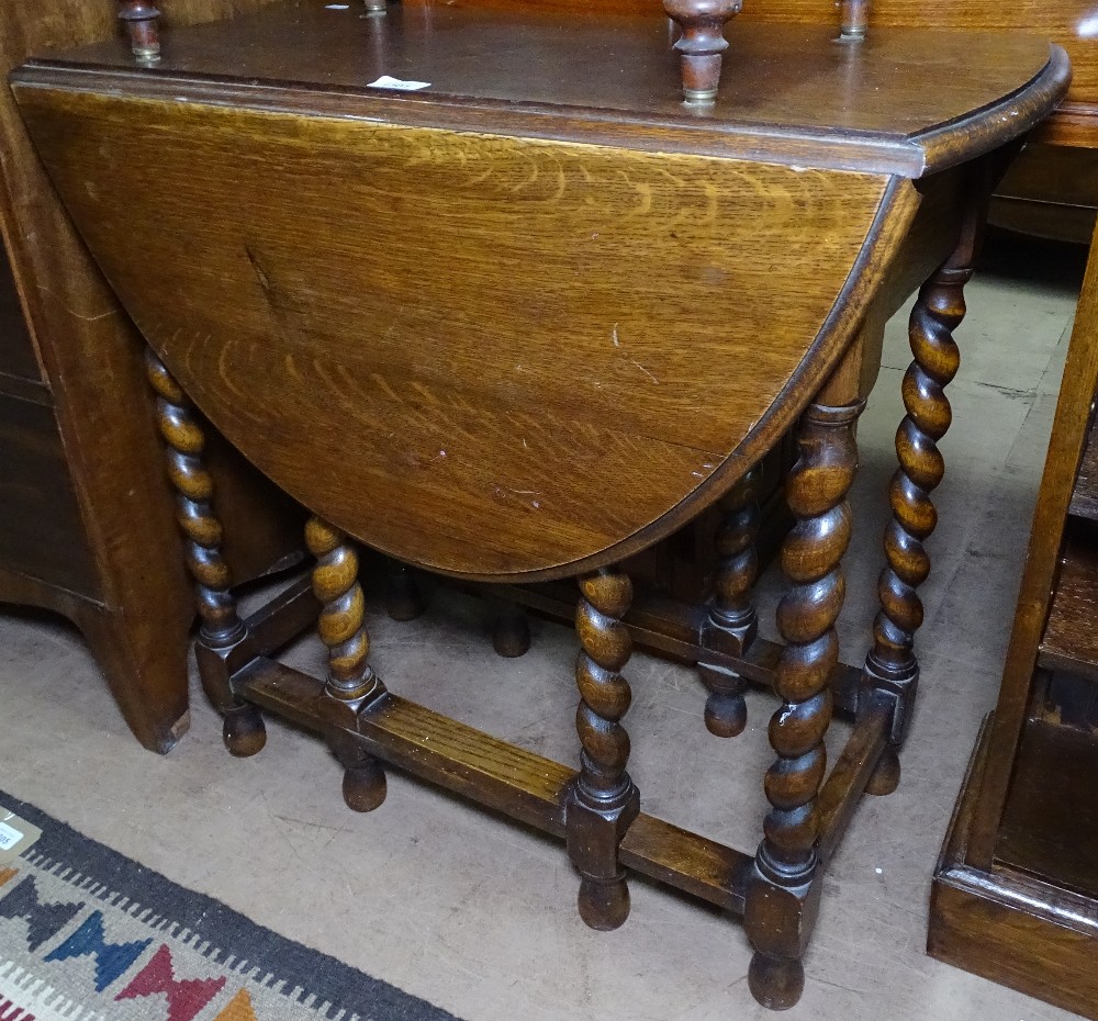 An oak oval gateleg table, with barley twist legs, W75cm