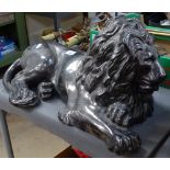 A silvered moulded figure of a resting lion, length 57cm