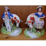 A pair of Staffordshire figures with cows