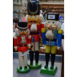 A graduated set of 3 painted wood soldier nutcrackers, tallest 39cm