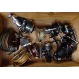 A pine box containing various fishing reels