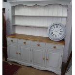 A large painted and polished pine dresser, with boarded open plate rack, above 4 frieze drawers,