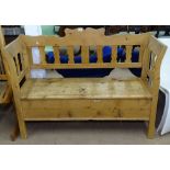 A Continental polished pine settle with rising seat, W130cm, H98cm