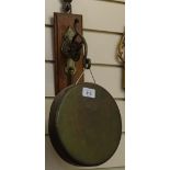 A brass gong on oak plaque, and striker, gong diameter 20cm