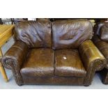 A pair of brown leather upholstered 2-seater settees, with loose cushions