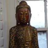 A carved painted and gilded wood Buddha on plinth, set with stones, height 102cm overall