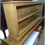 A modern polished pine low open bookcase, on bracket feet, W183cm, H83cm