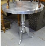 A circular chrome pub table on tripod base