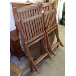 A stained hardwood circular folding garden table, and a pair of chairs