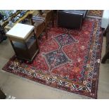 A large red ground Beluchi wool carpet with symmetrical border, 300cm x 215cm