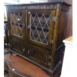 An oak bookcase with 2 leadlight glazed panelled doors, cupboards under, bracket feet, W107cm