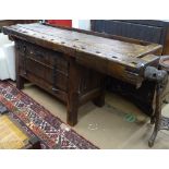 An Antique stained pine 2-section workbench, with fitted wood vice and cupboard base, L204cm, H84cm,