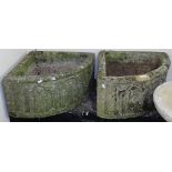 A pair of weathered concrete corner planters